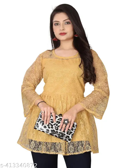 Gold lace top holding a black-and-white leopard print clutch. She wears red earrings, rings, and a confident expression