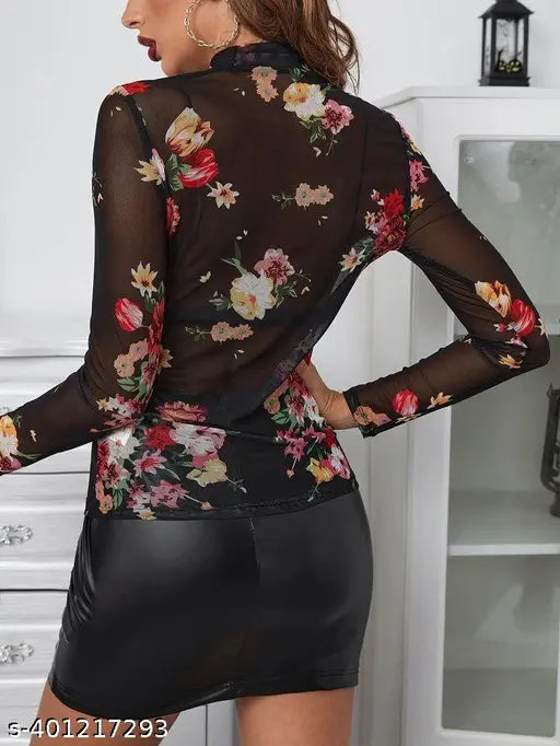 black floral sheer top and black leather skirt. The room has a white cabinet and a lantern decor.