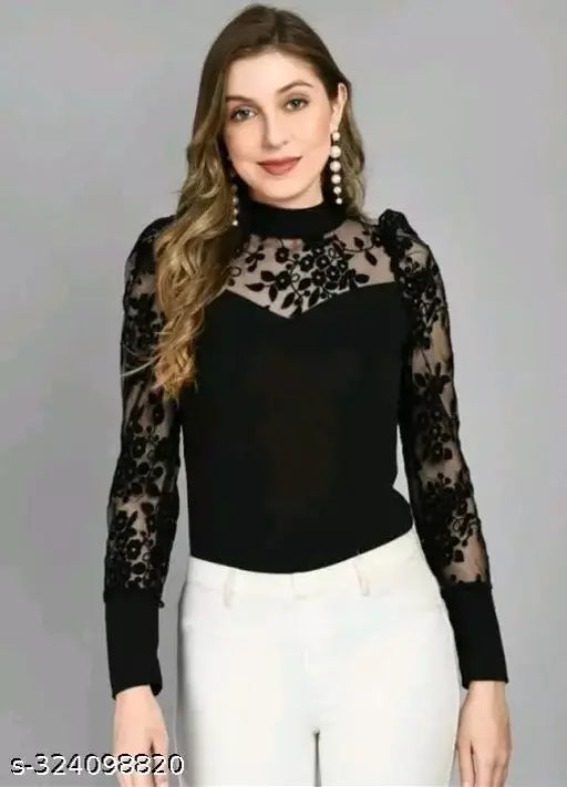 black lace top with floral patterns and sheer sleeves, paired with white pants. She has long wavy hair, and wears dangling earrings, smiling gently.