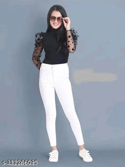 sunglasses, a black top with sheer polka dot sleeves, white pants, and white sneakers.