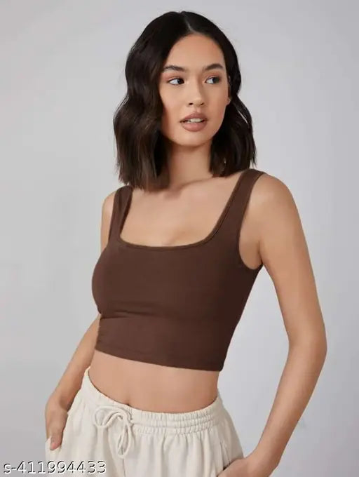  shoulder-length dark hair wears a brown tank top and cream drawstring pants. S