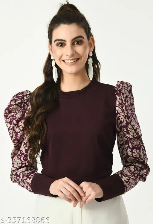  brown top with intricate floral-patterned puffed sleeves and white pants   white earrings.