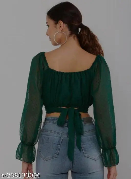 green, long-sleeve, puffed blouse with a tied back, and blue high-waisted jeans.