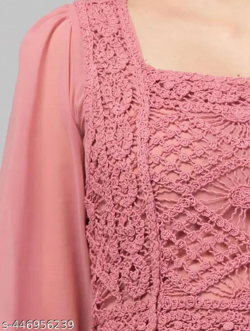  pink blouse featuring intricate crochet lace detailing on the chest and sleeves. The soft fabric and detailed design suggest elegance and femininity.