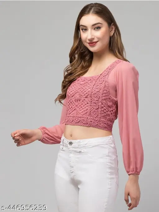 pink lace top with sheer sleeves and white pants.