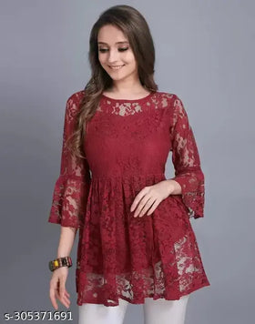 A woman in a red lace top with bell sleeves. She exudes a calm, elegant demeanor.